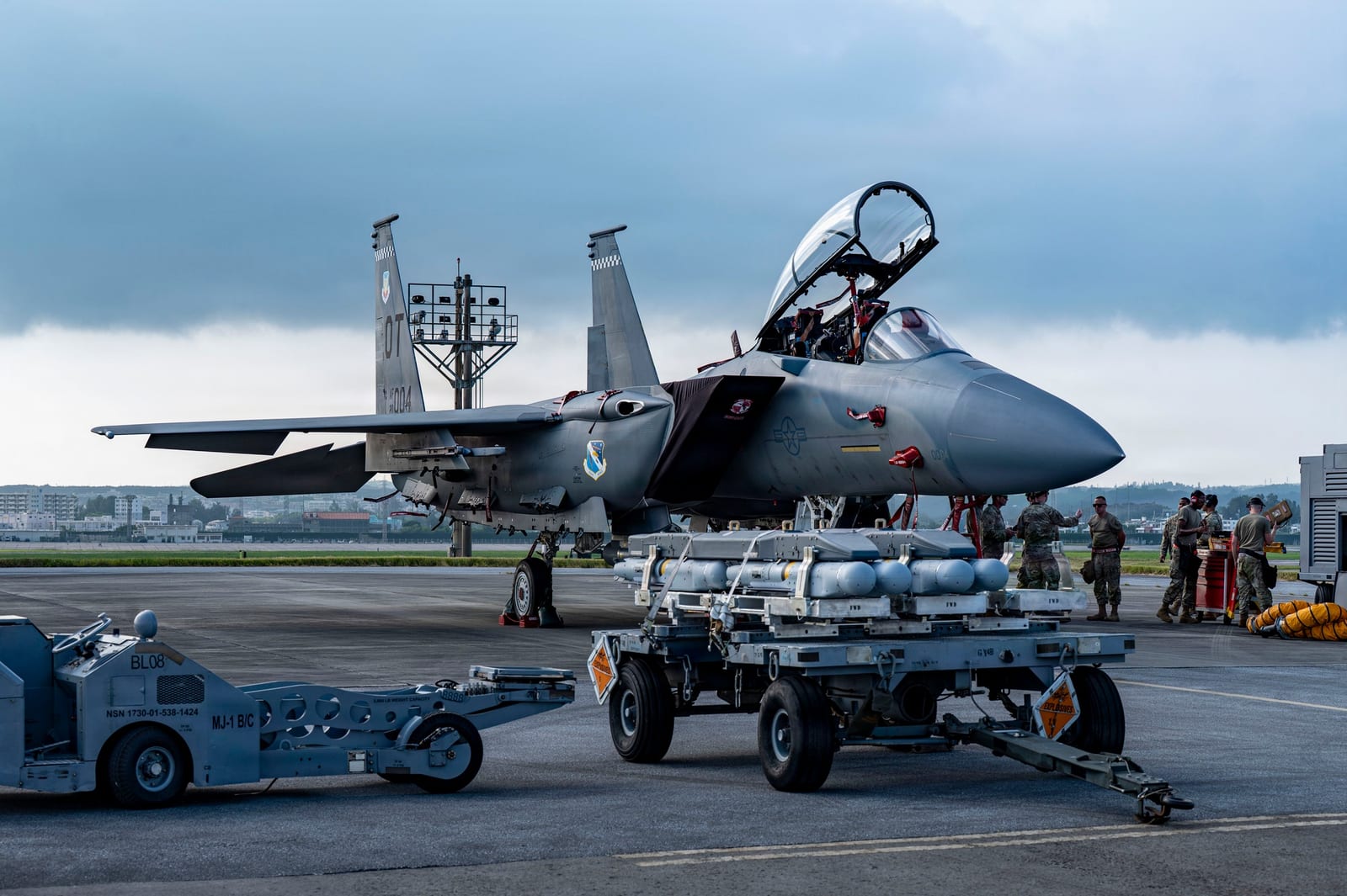 U.S. Air Force Airmen from the 67th Fighter Generation Squadron load munitions onto an F-15EX Eagle II at Kadena Air Base