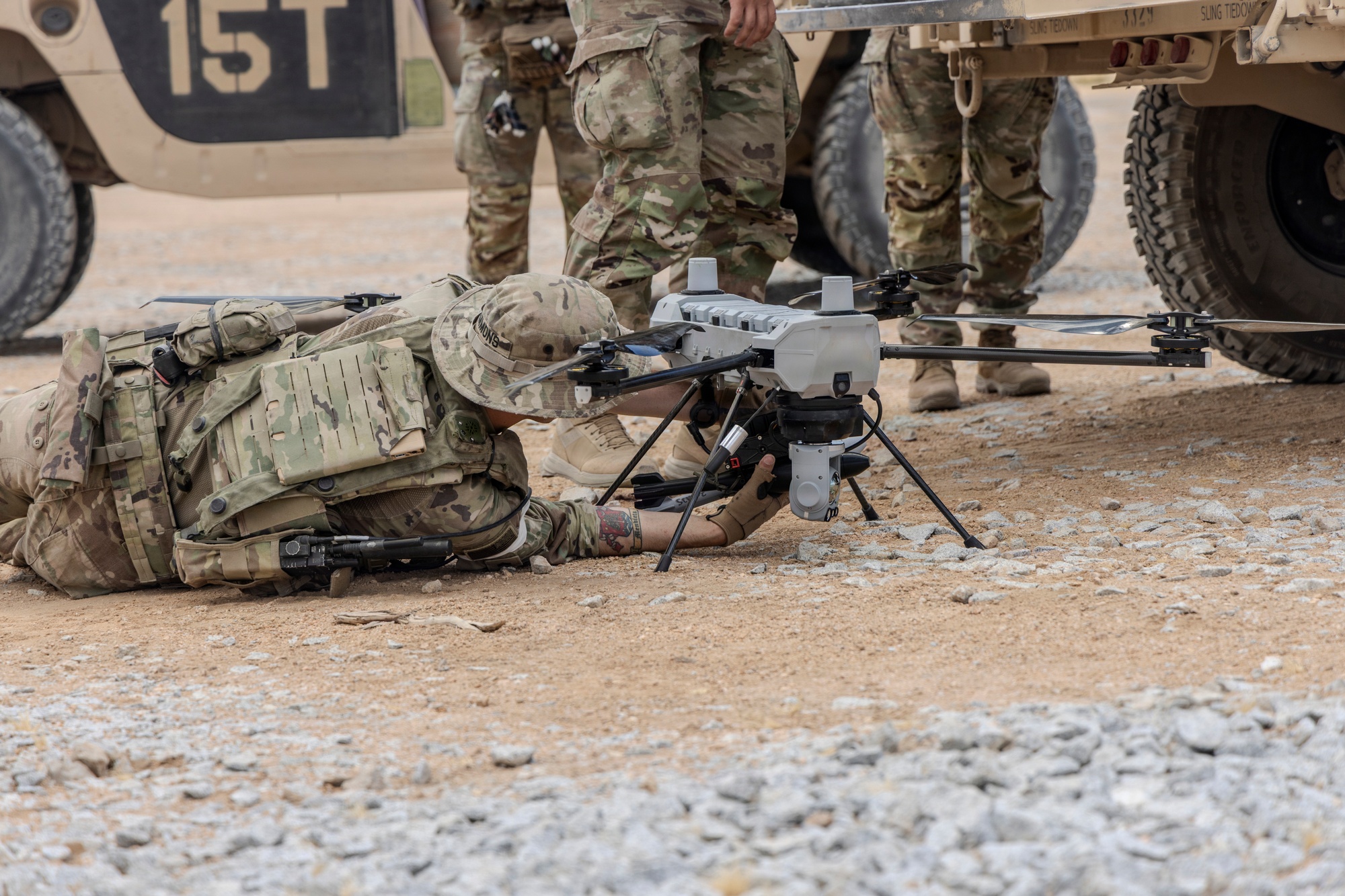 A U.S. Army soldier moves a PDW C-100 Defense drone fitted with the Picatinny Common Lethality Integration Kit during Project Convergence Capstone 6 at Fort Irwin, California