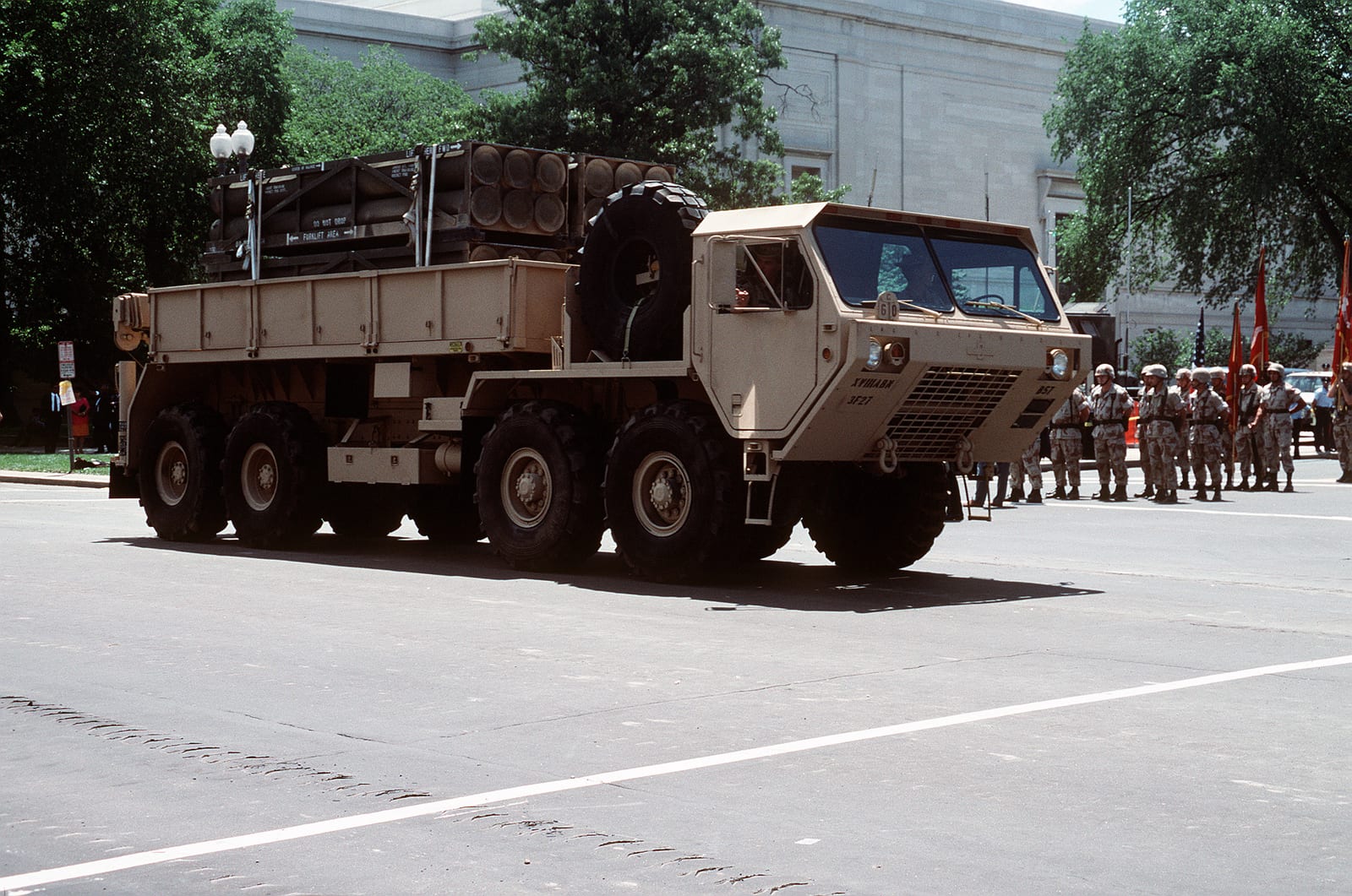 A Heavy Expanded Mobility Tactical Truck (HEMTT) carrying multiple launch rocket system pods during a 1991 parade