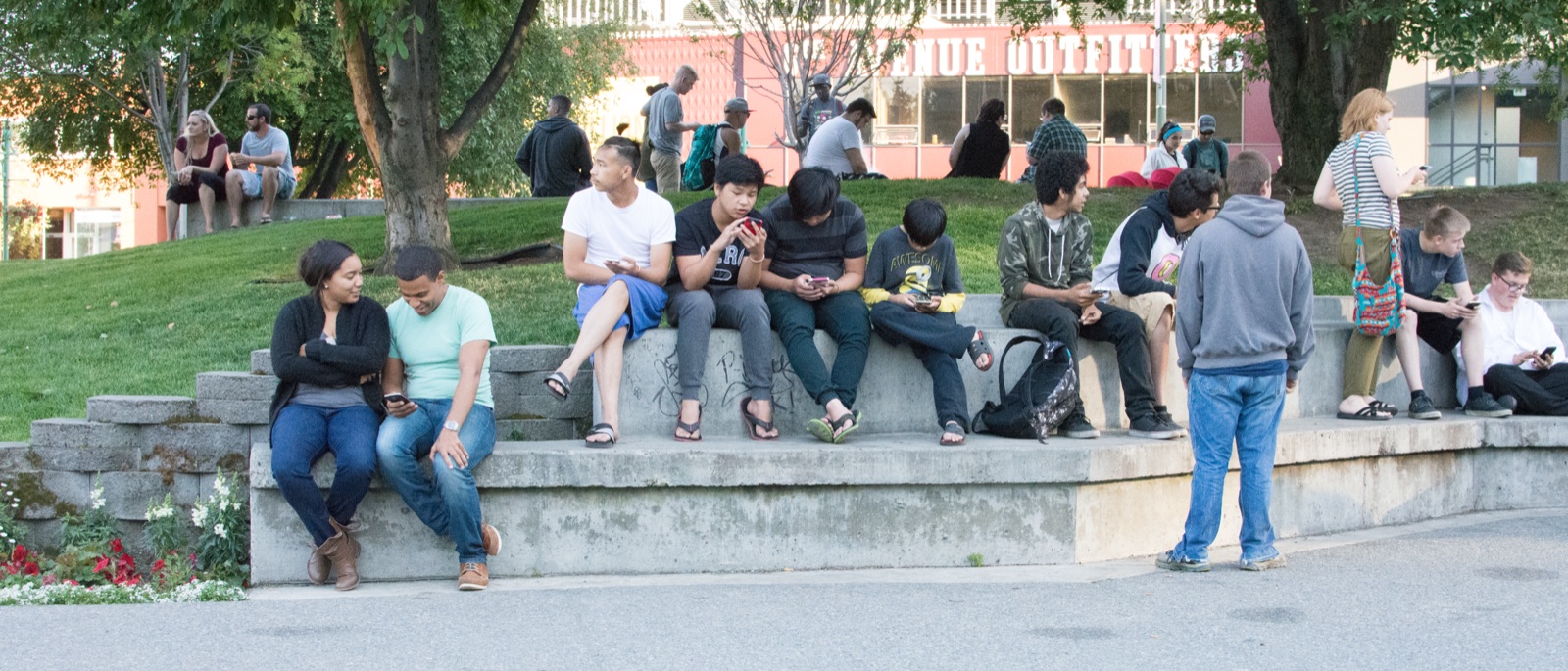 A crowd of Pokemon Go players stand together outdoors looking at their smartphones in a park in Anchorage, Alaska, in July 2016