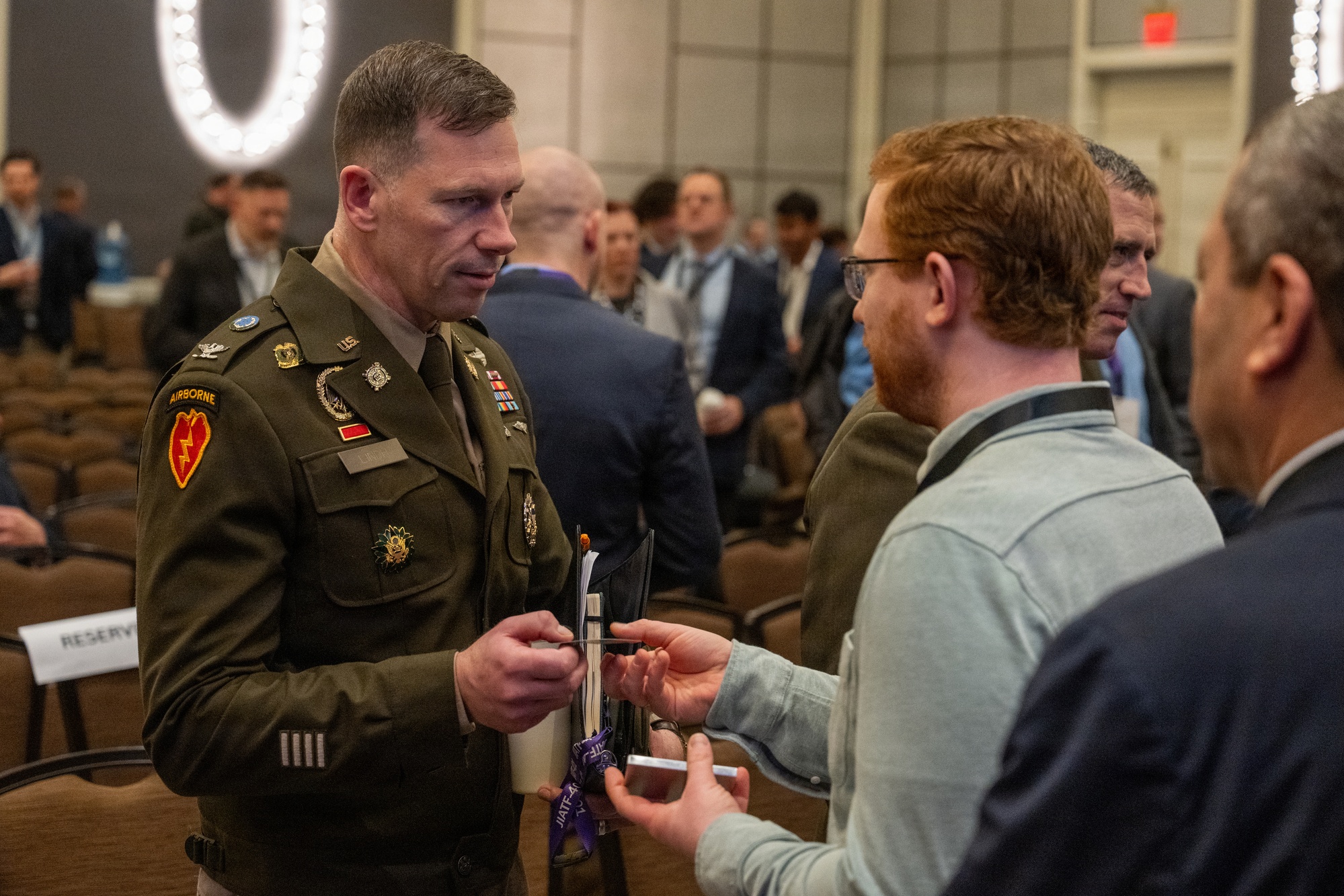 Military and industry personnel gather at a counter-drone industry day event, viewing equipment displays