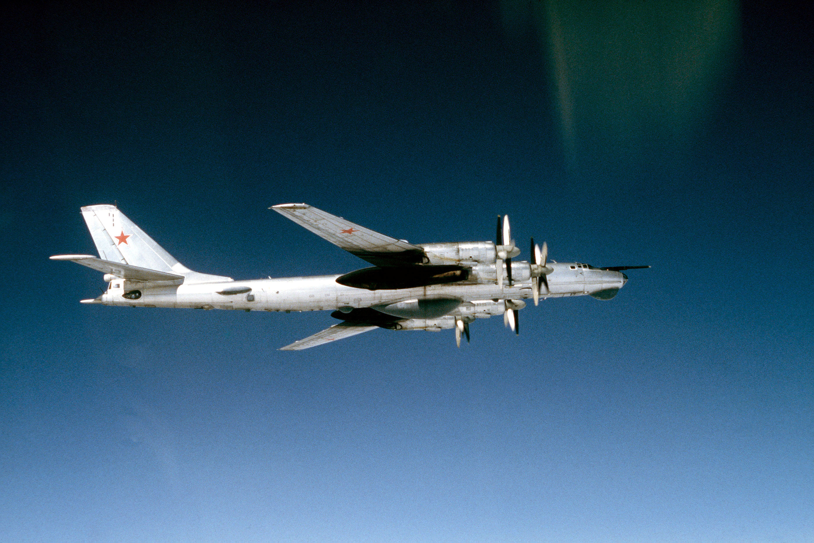 A Tu-95 Bear strategic bomber in flight, viewed from below